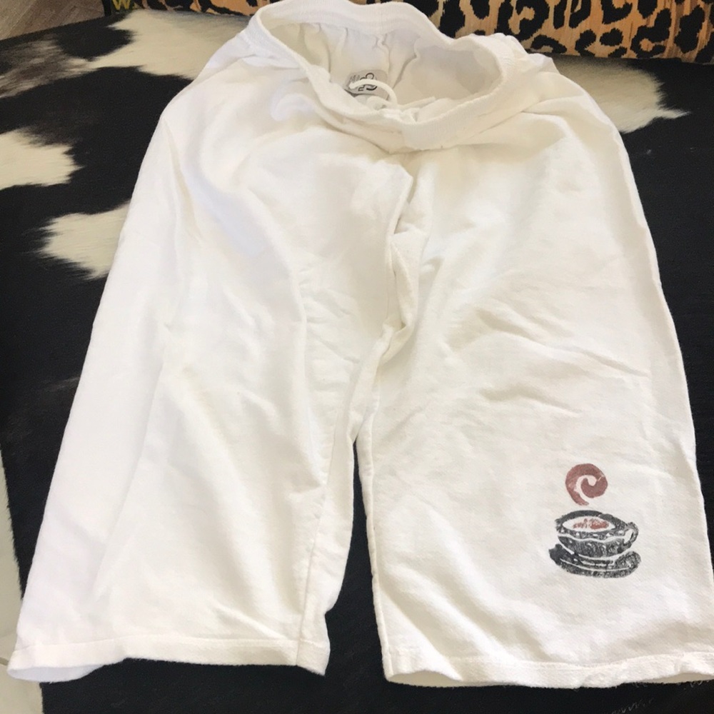 White capris with coffee cup on leg